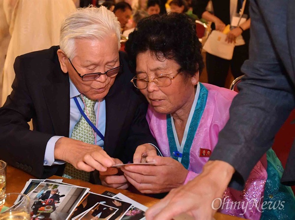 20일 금강산호텔에서 열린 제21차 남북 이산가족 단체상봉 행사에서 남측 유관식(89) 할아버지가 딸 유연옥(67)과 사진을 보고 있다.