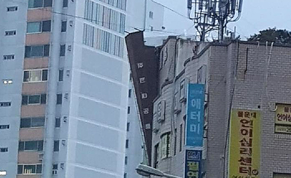24일 새벽 부산 사하구 다대동의 6층 건물 옥상에 있던 교회 첨탑이 강풍에 부러져 매달려 있다.