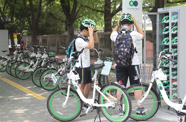 7월 20일 오후 서울 여의도 지하철5호선 여의나루역 1번 출구 앞 따릉이 대여소에서 청소년들이 공공자전거 따릉이를 대여하며 안전모를 써보고 있다.
