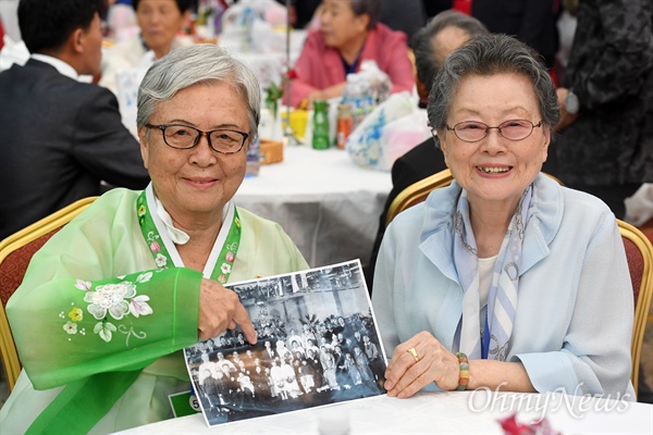  제21차 남북 이산가족 2차 상봉행사 둘째 날인 25일 금강산 면회소에서 열린 단체상봉에서 북측 안세민(80·왼쪽)씨가 가족사진을 보여주고 있다.