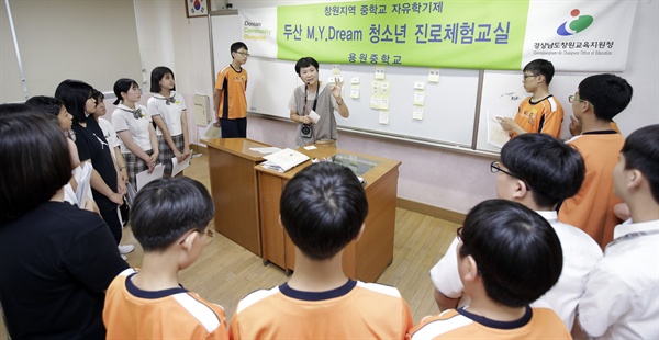 창원시 진해구 용원중학교에서 열린 ‘2018 두산 마이드림 청소년진로체험교실’ 발대식에서 프로그램 진행 관계자가 진로 탐색, 체험, 설계 등 3단계로 구성된 프로그램 일정과 진행 방법 등을 학생들에게 설명하고 있다.