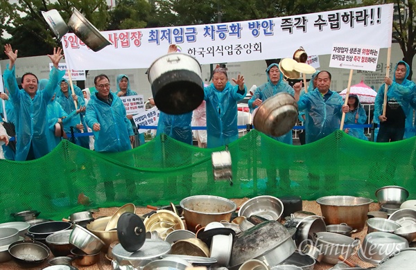 전국 소상공인들이 8월 29일 오후 서울 종로구 광화문광장에서 열린 ‘최저임금 제도개선 촉구 국민대회’에 참석해 자영업자 생존권을 위협하는 최저임금 인상 철회를 요구하며 솥단지와 냄비를 던지는 퍼포먼스를 벌이고 있다.