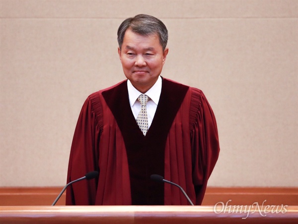 이진성 헌법재판소장이 30일 오후 서울 종로구 헌법재판소 대심판정에 입장해 자리에 앉고 있다.