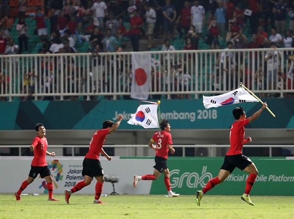 일본 꺾고 아시안게임 우승 1일 오후(현지시간) 인도네시아 자와바랏주 보고르 치비농의 파칸사리 스타디움에서 열린 2018 자카르타·팔렘방 아시안게임 남자축구 결승전 한국과 일본의 경기가 한국의 2-1 승리로 끝났다. 손흥민과 선수들이 경기 종료 휘슬이 울리자 태극기를 들고 그라운드를 누비고 있다.