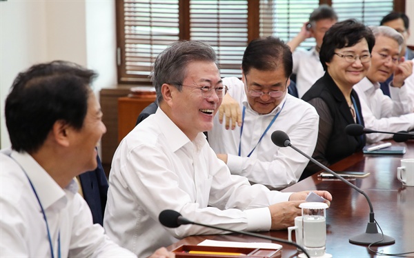 문재인 대통령이 3일 오후 청와대 여민관에서 열린 수석·보좌관 회의에서 발언을 마친 뒤 참석자들과 양복 상의를 벗고 본격적인 회의를 시작하며 미소짓고 있다.