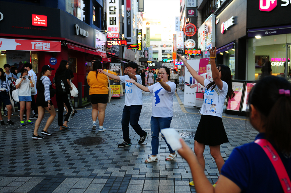 대전청년회 회원들이 통일 노래에 맞춰 몸짓을 하자 지나가는 사람들이 발길을 멈추거나 눈길을 보내고 있다.