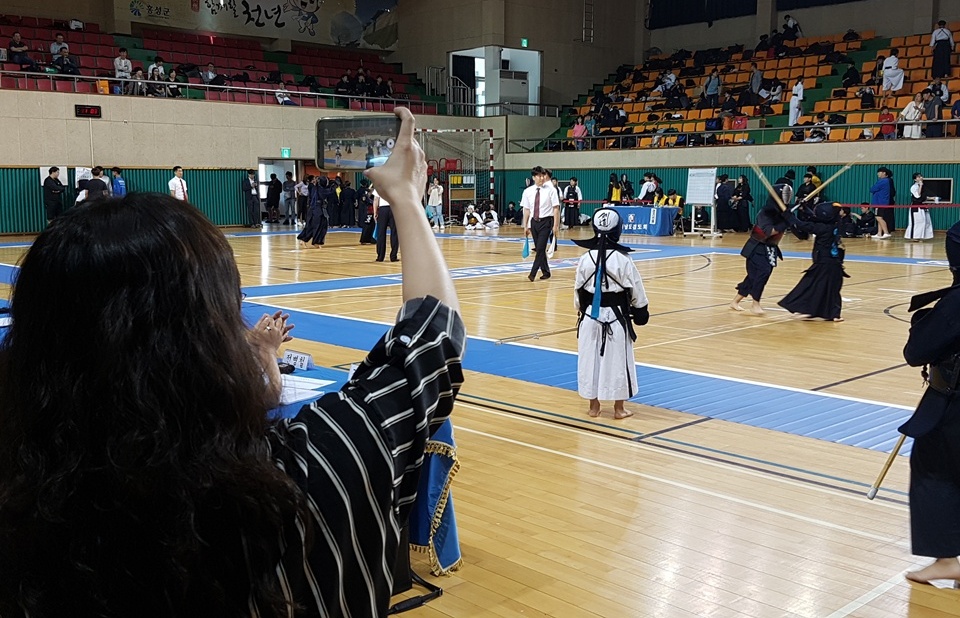  '2018 교육감배 학교스포츠클럽 검도대회'가 열린 8일 홍성 홍주문화체육센터에는 학생들뿐만 아니라 학부모도 함께 참가해 응원했다. 한 학부모가 시합장면을 촬영하고 있다. 