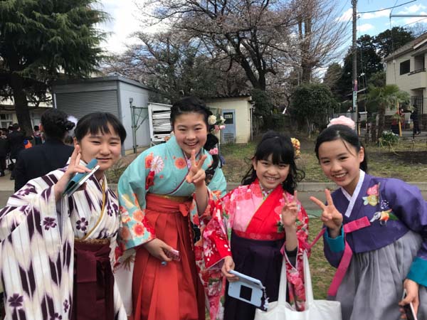 초등학교 졸업식에서 치마저고리를 입고 일본 아이들과 함께 즐거워하는 첫딸 미우.