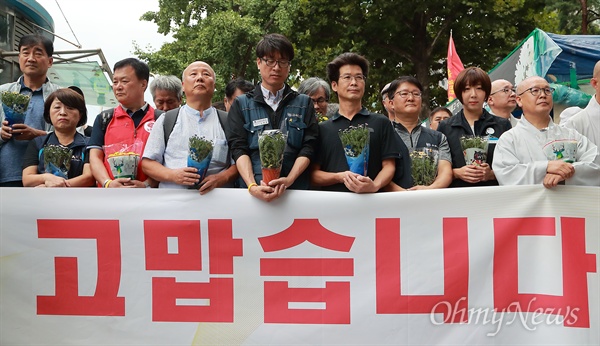  쌍용차 해고노동자 복직 잠정 합의안이 발표된 14일 오전 서울 덕수궁 대한문앞 희생자 합동분향소에서 김득중 금속노조 쌍용차지부장을 비롯한 시민노동단체 회원들이 기자회견을 하고 있다. 참석자들이 희생노동자들을 추모하며 화분을 들고 있다.