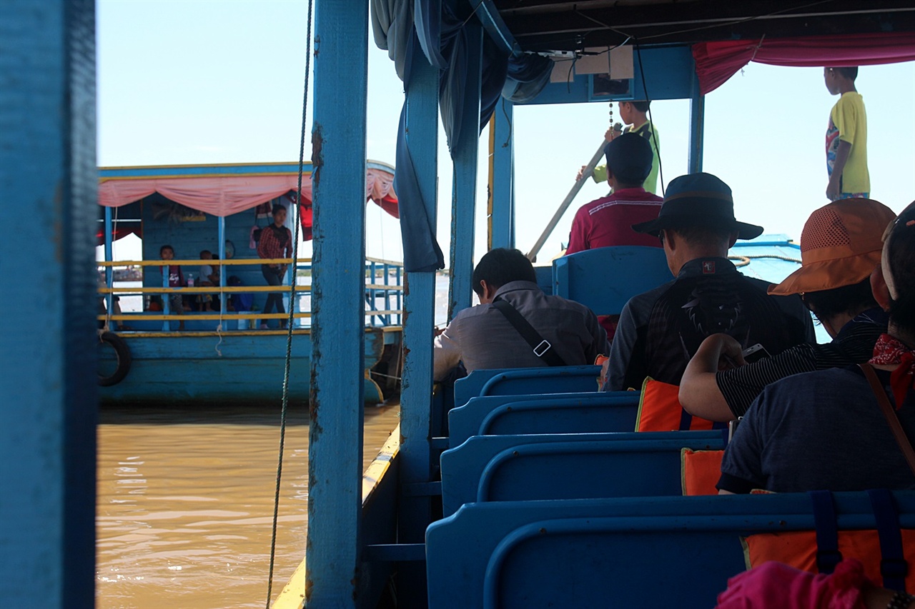 톤레샵 호수 목선에 승선하여 선장의 지시에 따르는 아이들 모습