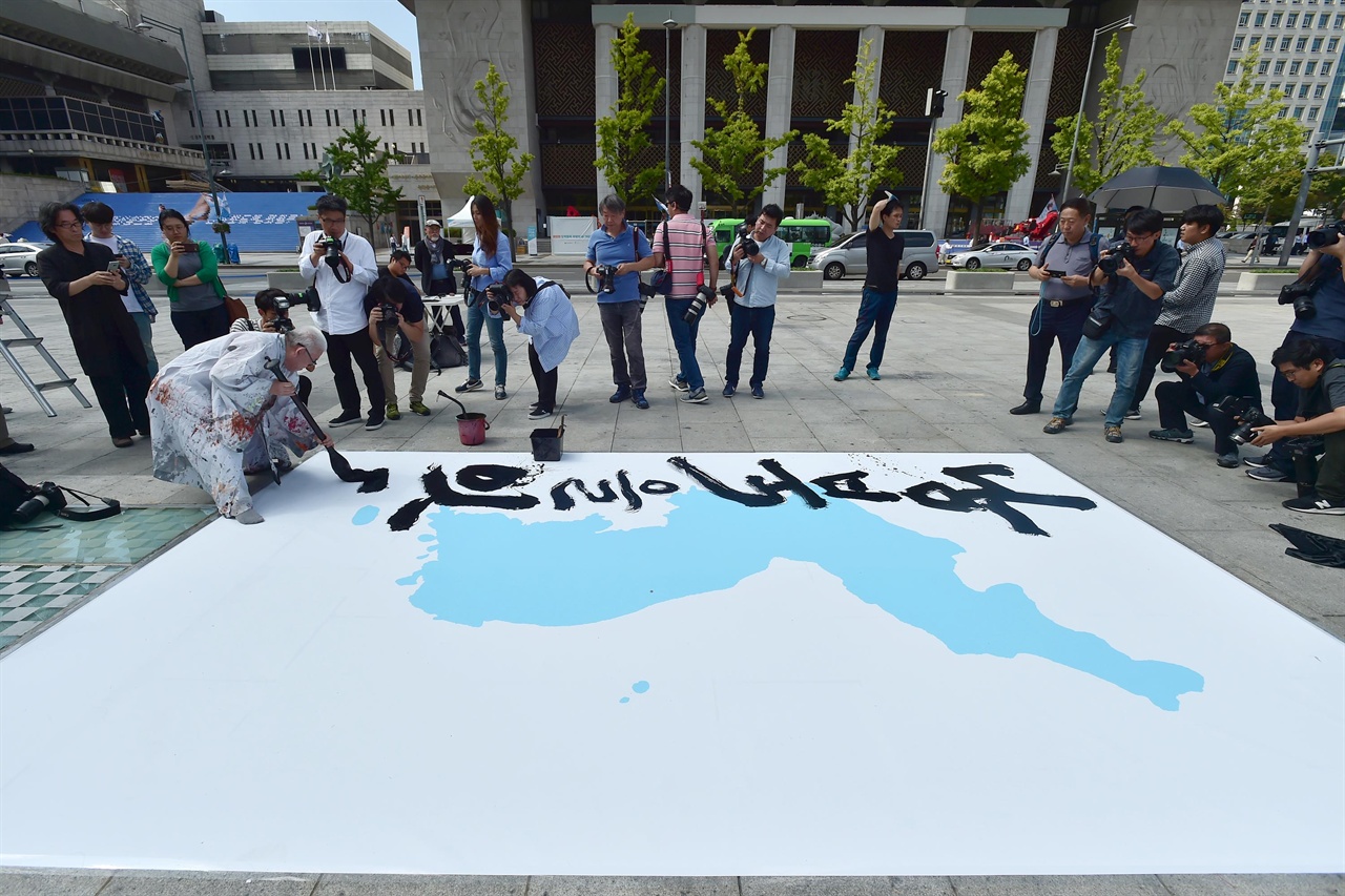 지난 4.27 남북정상회담 기념식수 표지석 글씨를 헌정한 바 있는 여태명 서화가가 문재인 대통령과 김정은 북한 국무위원장과의 제3차 남북정상회담을 하루 앞둔 17일 오후, 서울 종로구 광화문광장에서 남북정상회담의 성공을 기원하며 '남북을 잇다, 통일을 열다' 대형 붓글씨 퍼포먼스를 벌이고 있다. 2018.09.17