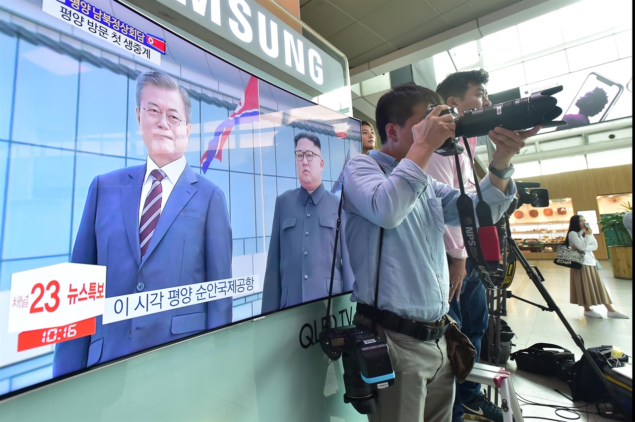  18일 오전 서울 용산구 서울역 대합실에서 한 사진기자가 제3차 남북정상회담을 위해 북한의 평양 순안공항에 도착한 문재인 대통령과 김정숙 여사가 김정은 북한 김정은 국무위원장과 리설주 여사가 만나는 모습을 취재하고 있다. 2018.9.18