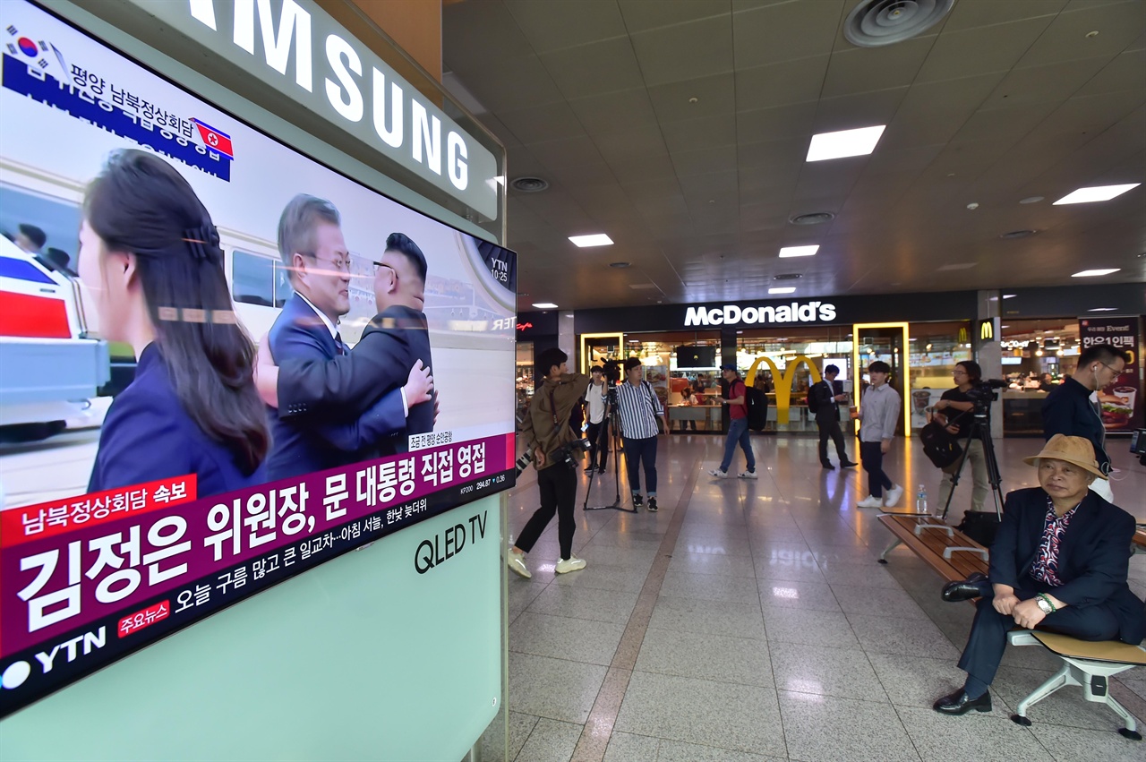  18일 오전 서울 용산구 서울역 대합실에서 열차를 기다리던 승객들이 제3차 남북정상회담을 위해 북한의 평양 순안공항에 도착한 문재인 대통령과 김정숙 여사가 김정은 북한 김정은 국무위원장과 리설주 여사가 만나는 모습을 TV 생중계를 통해 지켜보고 있다. 2018.9.18