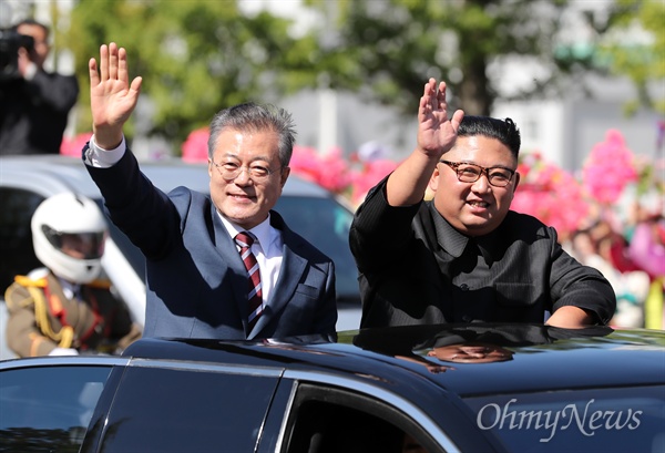 문재인 대통령과 김정은 국무위원장이 18일 오전 평양 시내를 카퍼레이드 하며 환영하는 평양 시민들에게 손을 들어 인사하고 있다