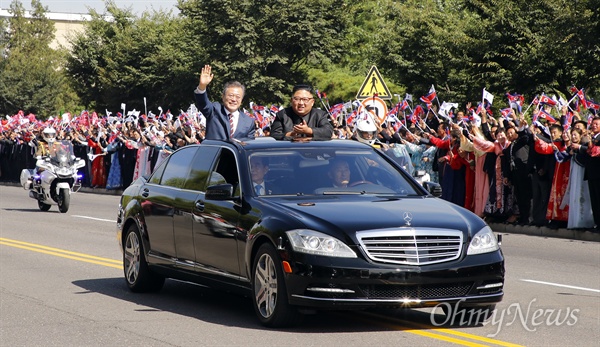 지난해 9월 18일 문재인 대통령과 김정은 국무위원장이 평양 시내를 카퍼레이드 하며 환영하는 평양 시민들에게 손을 들어 인사하고 있다