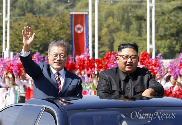 문재인 대통령과 김정은 국무위원장이 9월 18일 오전 평양 시내를 카퍼레이드 하며 환영하는 평양 시민들에게 손을 들어 인사하고 있다