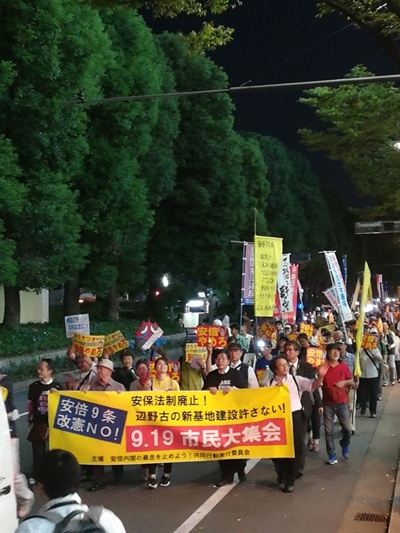 참가자들이 아베 퇴진을 외치며 행진하고 있다