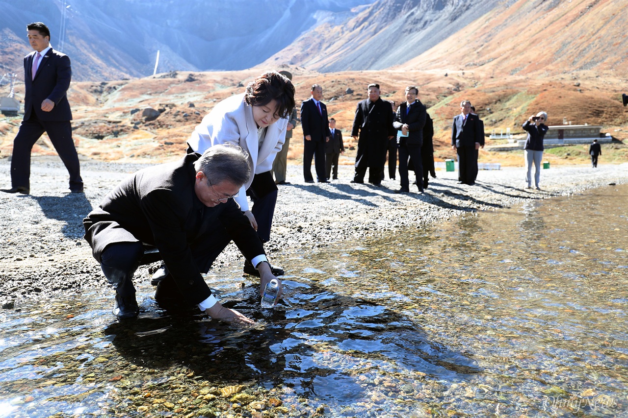문재인 대통령이 20일 오전 김정은 국무위원장과 백두산 천지를 산책하던 중 천지 물을 물병에 담고 있다. 