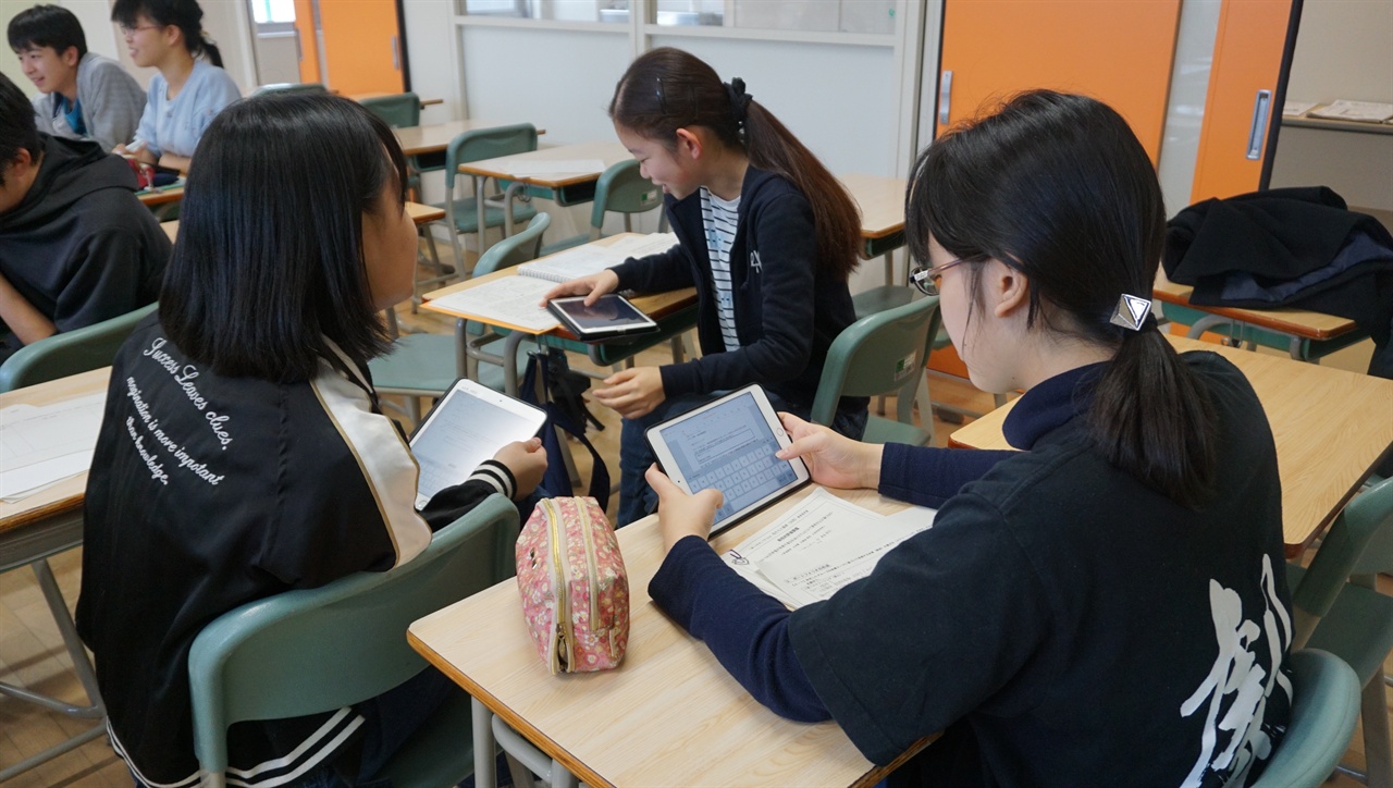 삿포로 가이세이 중등교육학교 3학년 학생들이 사회 수업 시간에 아이패드로 자료를 검색하는 장면.