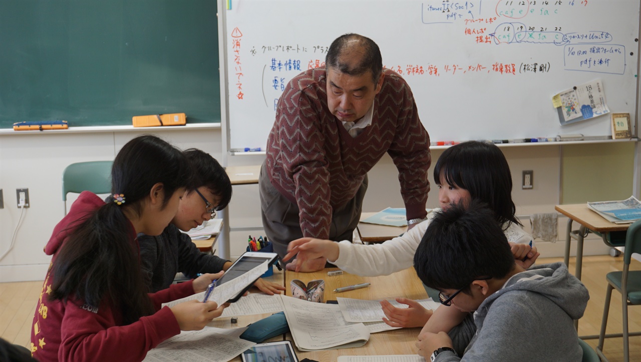  마츠자와 다케시 교사가 학생들의 보고서 작성 활동을 지켜보고 있다. 