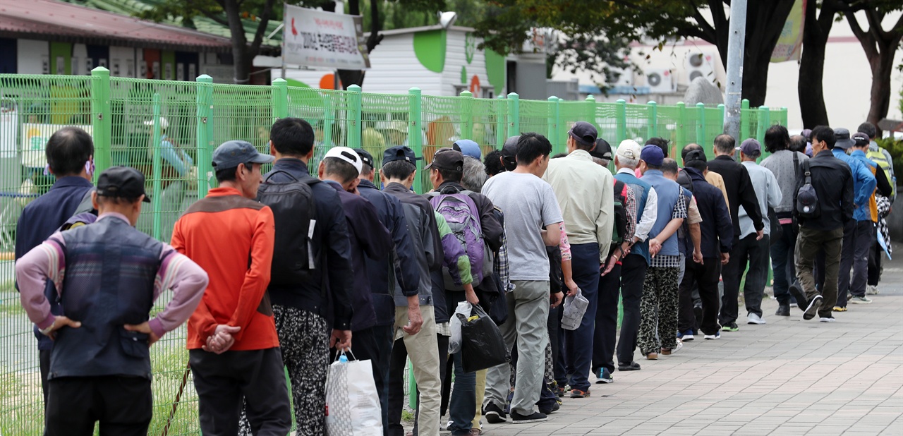 추석인 24일 오전 부산 동구 부산진역 무료급식소에서 점심을 먹기 위해 길게 줄을 선 사람들.
