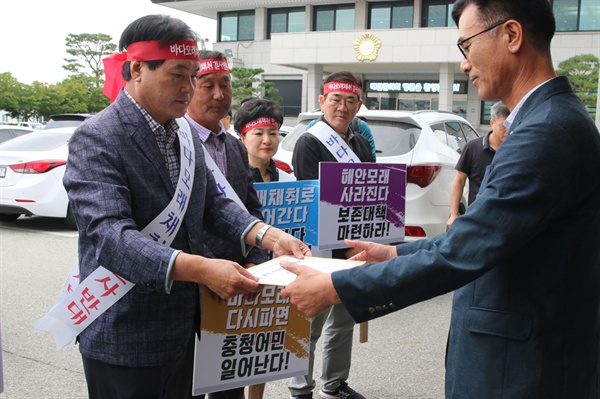 문정식 조합장이 김기준 태안군청 건설교통과장에게 성명서를 전달하고 있다.