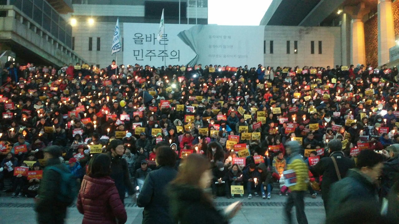 2016년 12월 세종문화회관 계단에서 최순실-박근혜 국정 농단 규탄 촛불 집회에 참여한 시민들이 촛불을 들고 있다