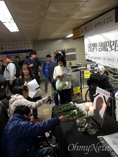 19일 서울 지하철 5호선 신길역에서 열린 장애인 리프트 추락참사 1주기 추모제에 참석한 장애인들이 리프트 희생자에게 헌화하고 애도하고 있다.