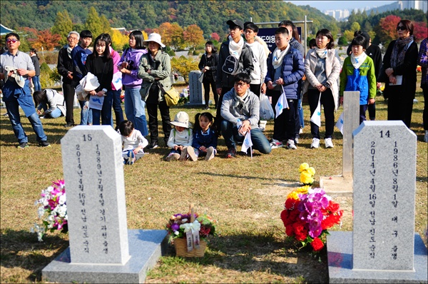 순직공무원묘역에 안장된 세월호 교사들의 사연을 듣고 있는 참석자들. 순직공무원묘역에는 세월호 순직 교사 10명이 안장되어 있다.