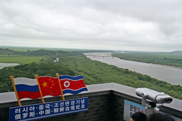 중국과 러시아 북한의 국경이 동시에 만나는 두만강 하구 부근이다. 사진은 중국의 훈춘지역에서 바라본 풍경으로 두만강을 가로지르는 철교를 기준으로 왼쪽이 러시아의 하산진이며, 오른쪽이 북한의 두만강시이다.