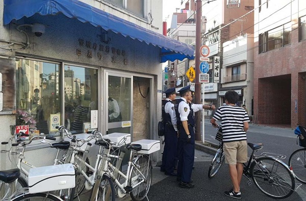 파출소 앞에서 외국인 관광객에게 길을 가르쳐주고 있는 일본 경찰관들.