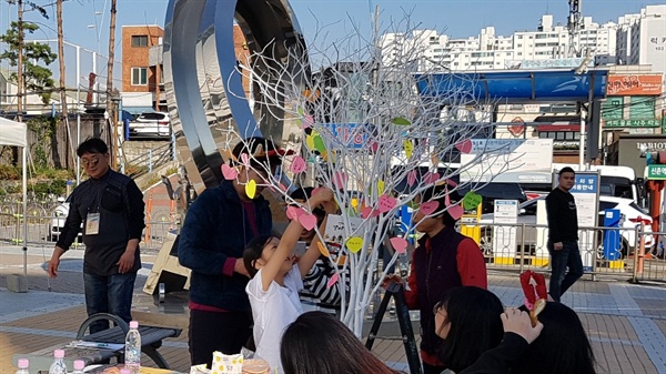 소망나무 시민들이 광장에 있는 소망나무에 소망을 써 붙이는 모습