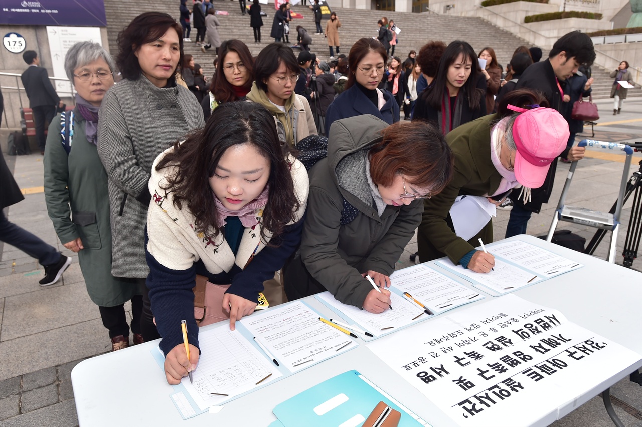  29일 오전 서울 세종로 세종문화회관 중앙계단에서 열린 ‘국가의 가정폭력 대응 강력규탄’  기자회견을 끝마친 여성단체 관계자들이 '강서구 아파트  살인사건' 가해자에 대한 엄벌을 촉구하는 서명용지에 서명을 하고 있다. 2018.10.29