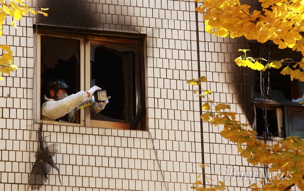 9일 오전 서울 종로구 관수동 한 고시원에서 화재가 발생해 10여명의 사상자가 발생한 가운데, 소방관이 불탄 고시원에서 폴리스라인을 설치하고 있다.