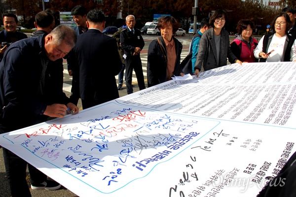 김영만 6.15공동선언실천 남측위원회 경남본부 상임대표를 비롯한 인사들이 11월 13일 오전 경남도청 정문 앞에서 "판문점 선언 국회 비준을 지켜내자"며 기자회견을 연 뒤, 선언문이 적힌 천에 서명을 했다.