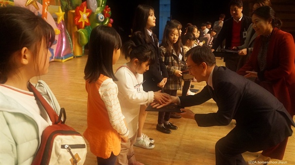 김삼호 광산구청장이 아동에게 시상후 악수하는 모습