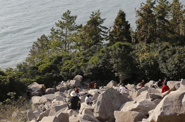 박세남 씨가 금곡해변 앞 너덜에서 여행객들과 함께 멍-때리기를 하고 있다. 왼쪽 아래, 모자를 쓴 사람이 그다.