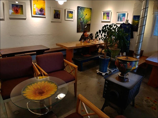 유화 그림에 이국적이고 짙은 색의 빈티지 소품과 앤틱 가구들이 정겹다.  노오란 꽃이 피어 있는 테이블은 미용실 의자를 거꾸로 뒤집어 만들었다.