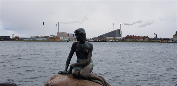 덴마크의 랜드마크인 인어상. 뒤로는 열병합 발전소가 연기를 내뿜고 있다. 덴마크는 풍력과 열병합 발전으로 전기를 생산해내고 있다.