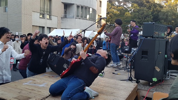 게이오대학 대학축제에서 스테이지에 오른 밴드의 열정적 공연에 학생들이 환호하고 있다.