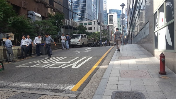  강남의 직장인들이 골목 뒷편에서 담배를 피우는 모습