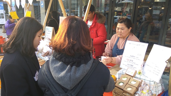 농업회사법인 둘래야의 천새미 팀장이 12월 1일 서울 종로구 안국동에 마련된 상생상회 매장에서 고객들에게 거제 유자차 시음을 권하고 있다.