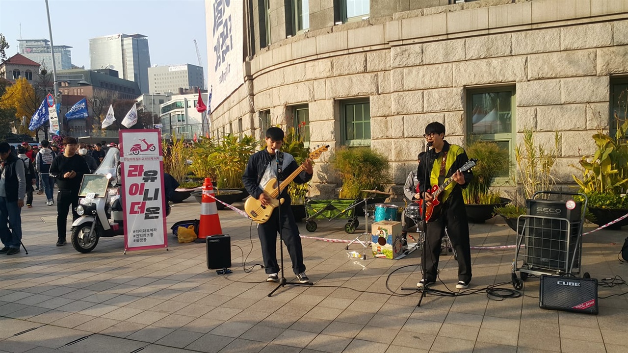  "라이더 유니온" 조합원이 활약하는 인디밴드 만모스, 시청광장 도서관 앞에서 버스킹공연 중이다.