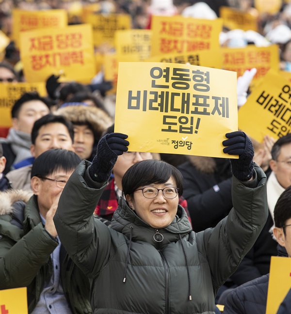 정의당의 한 당원이 연동형 비례대표제 도입을 촉구하는 손팻말을 들어 보이고 있다. 정의당은 이 제도 도입에 당력을 집중하는 양상이다. 