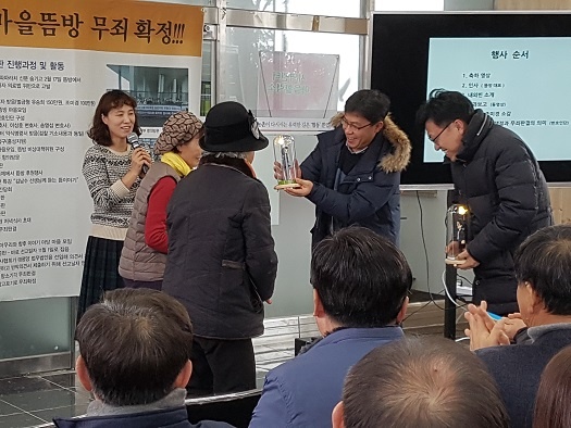 홍동 주민들이 하승수 송영섭 변호사에게 그들을 본떠 만든 인형을 선물하고 있다. 