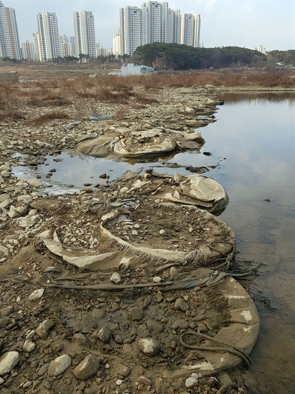 장맛비에 토사가 씻겨나간 곳에서 많은 양의 마대자루가 발견됐다.