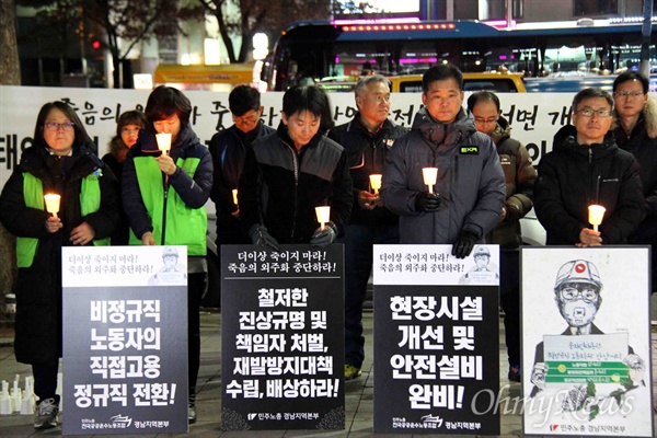 12월 18일 저녁 창원 정우상가 앞에서 열린 "태안화력 비정규직 24살 고 김용균님 추모문화제"에서 참가자들이 촛불을 들고 서 있다.