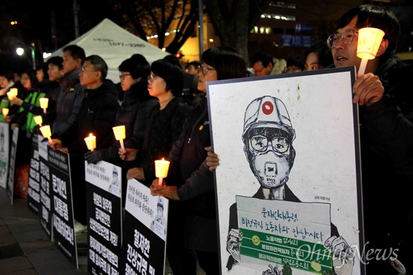 12월 18일 저녁 창원 정우상가 앞에서 열린 "태안화력 비정규직 24살 고 김용균님 추모문화제"에서 참가자들이 촛불을 들고 서 있다.