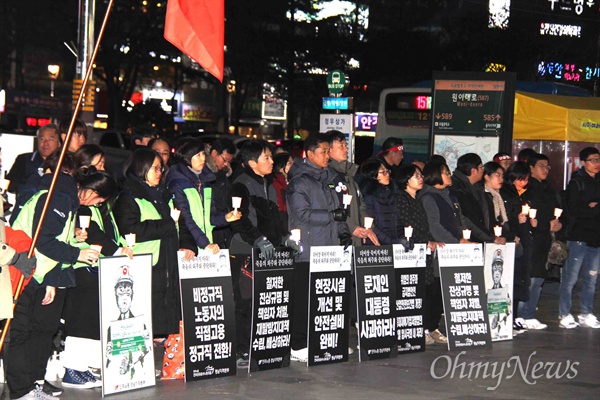  12월 18일 저녁 창원 정우상가 앞에서 열린 "태안화력 비정규직 24살 고 김용균님 추모문화제"에서 참가자들이 촛불을 들고 서 있다.