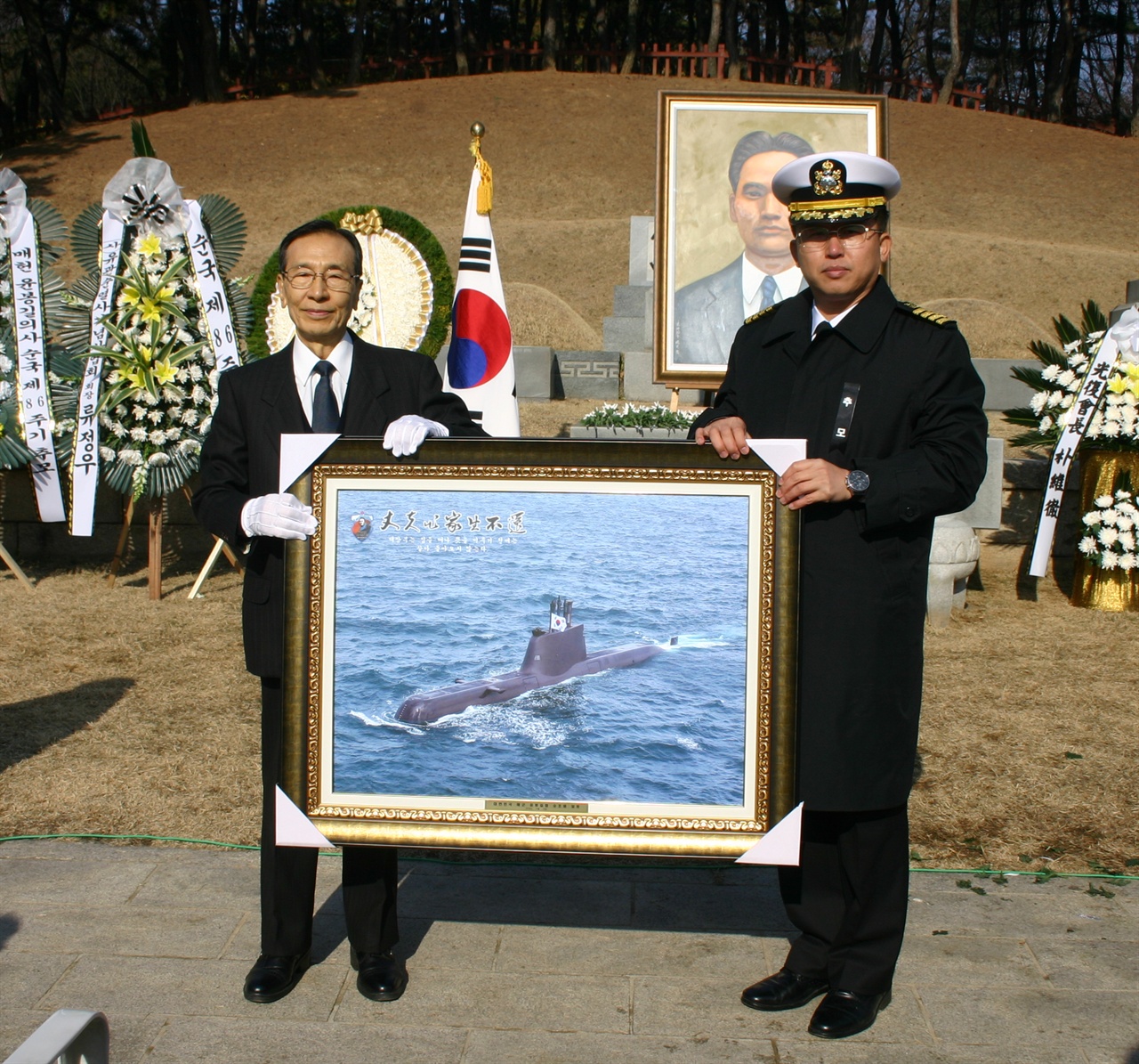 윤봉길함 함장이 윤봉길잠수함 사진을 황길수 기념사업회장에게 전하고 있다.